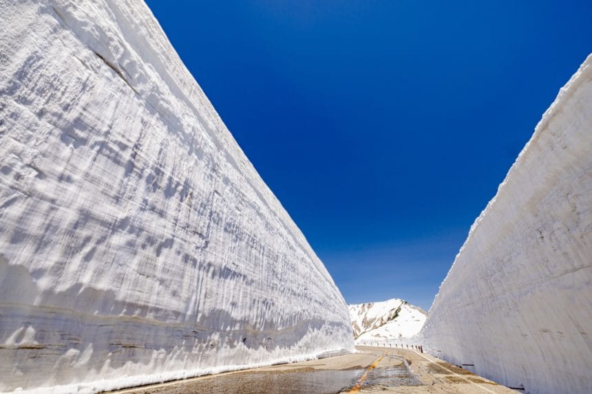 富山県 立山黒部アルペンルート 室堂・雪の大谷の巨大な雪の壁と青空