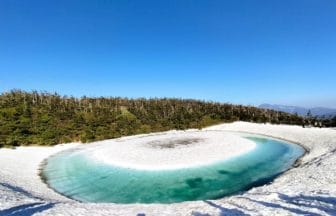 秋田県仙北市 八幡平ドラゴンアイ（鏡沼）雪解けで現れる青いリング状の水面
